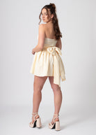 Korte katoenen bandeau off shoulder jurk lemon met volumineuze rok en strik. Romantische coquette stijl.