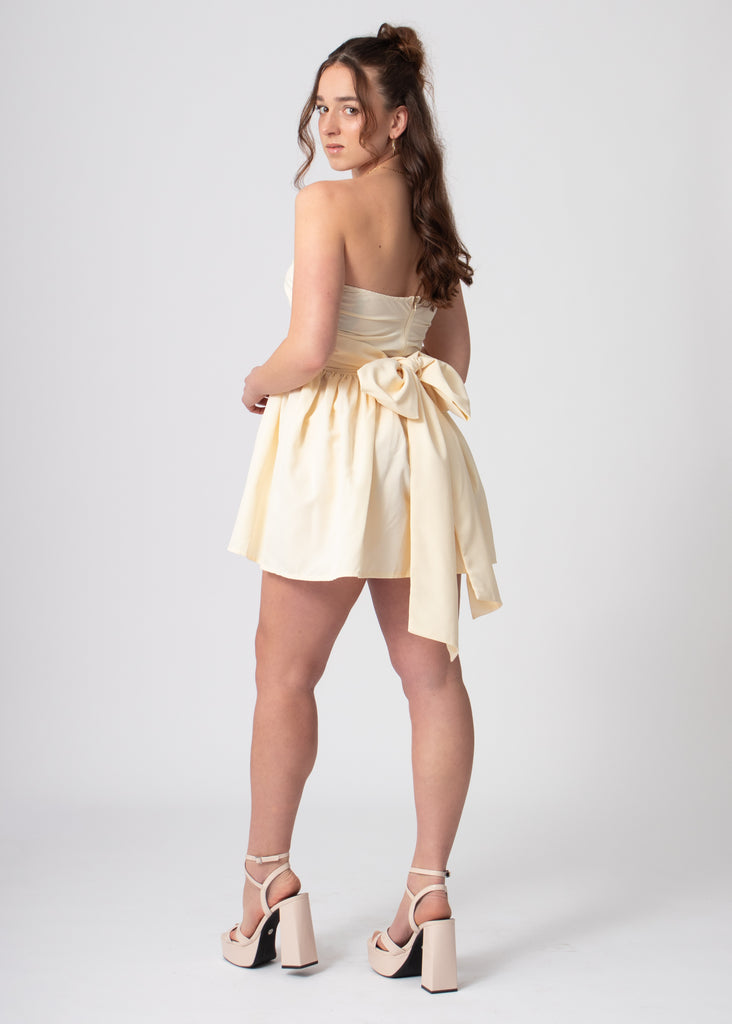 Korte katoenen bandeau off shoulder jurk lemon met volumineuze rok en strik. Romantische coquette stijl.