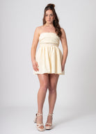 Korte katoenen bandeau off shoulder jurk lemon met volumineuze rok en strik. Romantische coquette stijl.