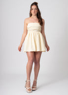 Korte katoenen bandeau off shoulder jurk lemon met volumineuze rok en strik. Romantische coquette stijl.